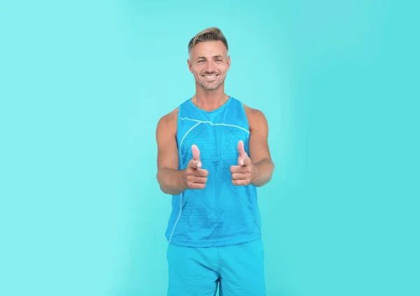 Happy sport athlete blue background. athlete smiling in sport wear. sport man athlete showing thumb up.