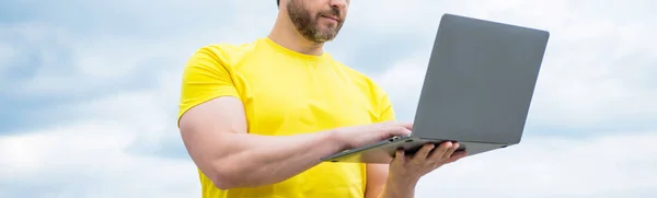 cropped view of man check email on laptop on sky background.