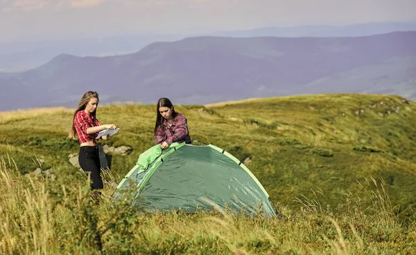 Talimatlara uyun. Grup arkadaşları dağın tepesine çadır kurdular. Takım çalışması konsepti. Yürüyüş aktivitesi. Çadır kurmada yardımcı olacak bir partnerim var. Kamp yürüyüşü. Gerekli yapısal bileşenler çadırını ekle.
