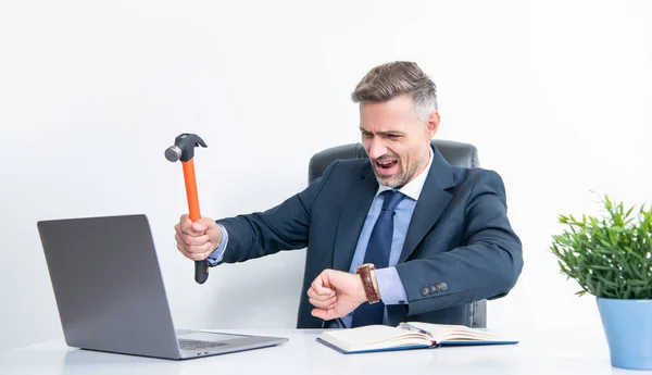 frustrated boss hitting laptop with hammer and checking time.