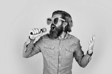 Canlı müzik. Karaoke şarkıcısı. Tıraşsız, uzun saçlı adam. Berber ve kuaför. Erkek mikrofonda şarkı söyler. Mikrofonlu komik sakallı adam. Parti gözlüklü vahşi beyaz hippi..