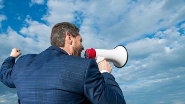 Gökyüzü arka planında hoparlörde iş adamının ajitasyonunun arka planı.