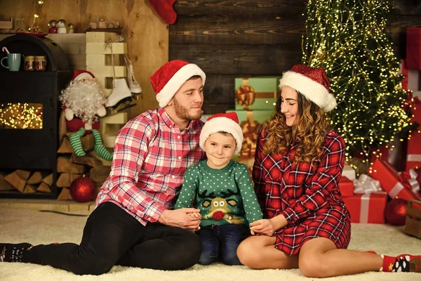 Christmas scene. family christmas portrait. happy family celebrate xmas. son with parents in santa hat. little kid boy love mom and dad. love spend holiday together. having fun. new year at home.