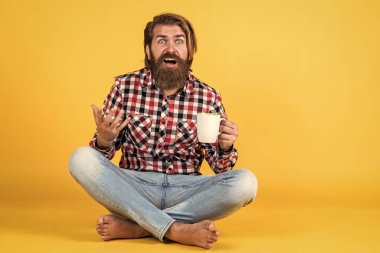 Şaşırtıcı sakallı, sakalsız, şık saçlı, sıradan kıyafetler giyen, kahve içen yakışıklı bir adam..