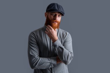 İrlandalı adam Grey 'de izole edilmiş. Kızıl sakalı okşayan ciddi bir adam. Sakallı adam stüdyosu.