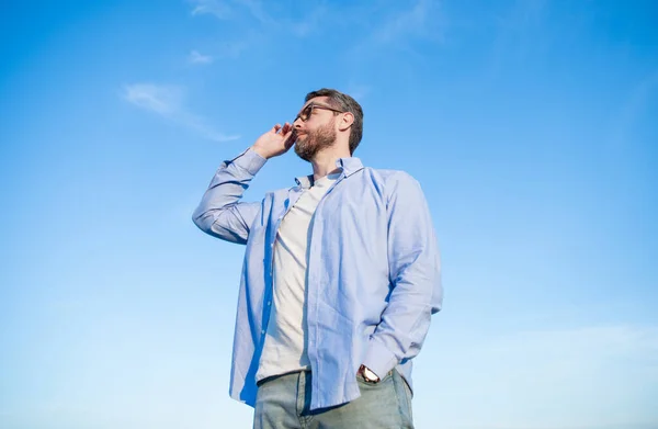 pensive caucasian man standing peaceful. pensive man in glasses outdoor. pensive man on sky background.