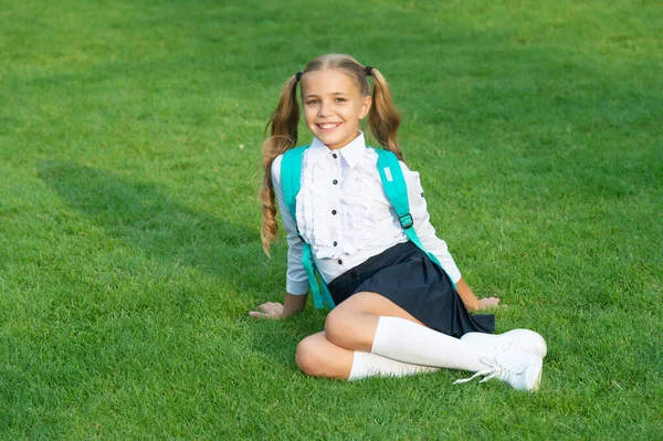 緑の芝生の上に座って学校の制服の幸せな10代の女の子 10代の女の子が学校に戻る 9月1日 学校教育 — ストック写真