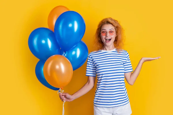 party woman with birthday balloon, copy space. happy birthday woman hold party balloons in studio. woman with balloon for birthday party isolated on yellow background.
