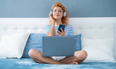 pozitif kız telefonda müzik dinliyor. Evde telefonu olan bir müzik kızı. Kulaklıklı kız müzik dinliyor..