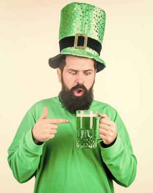 Alkol tüketimi Aziz Patrick Günü 'nün ayrılmaz bir parçası. İrlanda geleneği. Vahşi sakallı hippi adam yarım litre bira içiyor. İrlanda barı. Yeşil bira kupası. Bira içme kısmı kutlama. Bar sezonluk tatil menüsü.
