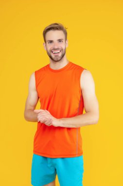 Sarıda izole edilmiş zinde bir adam. Mutlu Sporcu Stüdyosu. Spor giyim sektöründe sporcu. Atletik fitness. Spor ve eğlence sektörü. Spor ve spor.