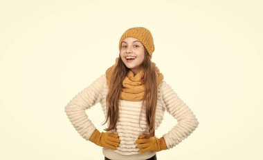 Şapka atkısı ve eldiven takan mutlu çocuk beyaz ve kalın giysiler içinde izole edilmiş..