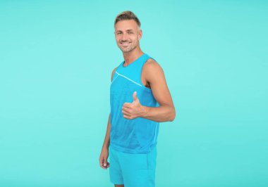 Neşeli fitness sporcusu mavi arka plan. Spor giyim sektöründe sporcu. fitness ve spor.
