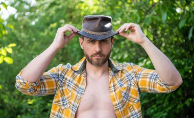 Kovboy şapkalı seksi adam. Kareli gömlekli seksi kovboy. Kovboy şapkalı..