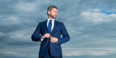 Profesyonel erkek gökyüzü geçmişi. Tıraşsız adam düğme ilikleme takımı. Ciddi adam dışarı bakıyor, boşluğu kopyalıyor..