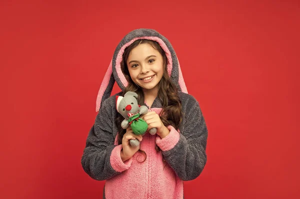 赤い背景にクリスマスのおもちゃで居心地の良い睡眠中の笑顔の子供 ホームウェア — ストック写真