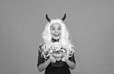 Teşekkür ederim. Oyuncak ayıyla şeytan boynuzları içinde gülümseyen bir çocuk. Çocuğun beyaz saç peruğu var. çocukluk mutluluğu. Genç kız kostüm partisini kutlamaya hazır. Komik kırmızı şeytan boynuzları. Mutlu cadılar bayramı.