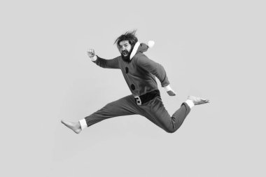 Noel kostümlü mutlu olgun adam sarı arka planda zıplıyor, xmas eğlenceli.