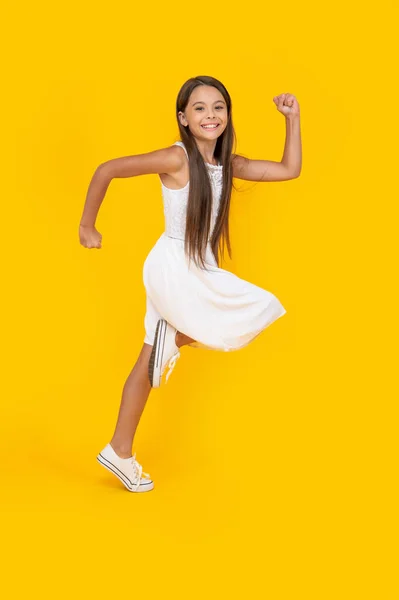 Happy Teen Girl White Dress Running Yellow Background — Zdjęcie stockowe