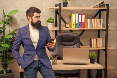 Ofiste cep telefonu kullanan profesyonel bir adam, iş adamı.