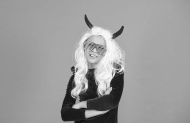 funny red imp horns. happy halloween. smiling child in devil horns and party glasses. kid has long white hair wig. childhood happiness. teen girl ready to celebrate costume party. I am the treat.
