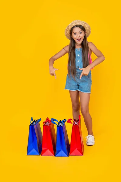 Gelukkig Tiener Meisje Wijzen Vinger Boodschappentassen Gele Achtergrond Volledige Lengte — Stockfoto
