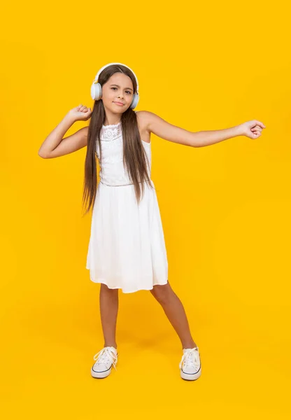 Улыбающаяся Девочка Слушает Музыку Наушниках Танцует Желтом Фоне — стоковое фото