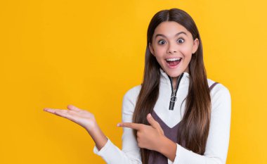 sarı arka planda uzun saçlı bir çocuk. ürün sunuluyor.