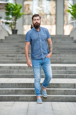 Sakallı adam aşağı iniyor. Uzun boylu, sakallı bir adam. Hipster adam dışarıda..