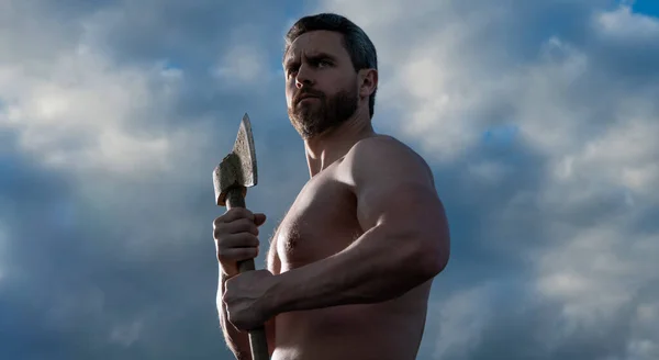 shirtless man with axe. logger man hold ax. brutal man on sky background.