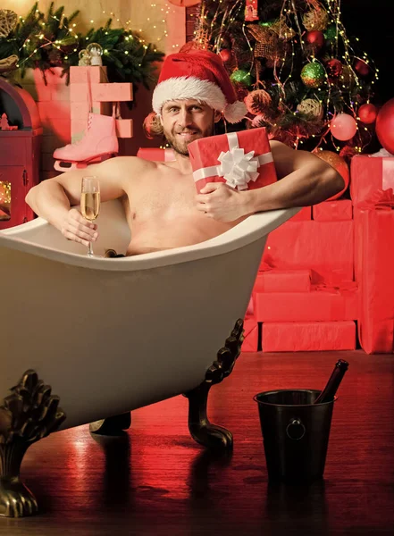 Holiday atmosphere. best xmas gift. christmas spa. muscular man relax bathtub. macho drink champagne after party. sexy mature man bath. winter holidays. happy new year gift. erotic wish. feel desire.