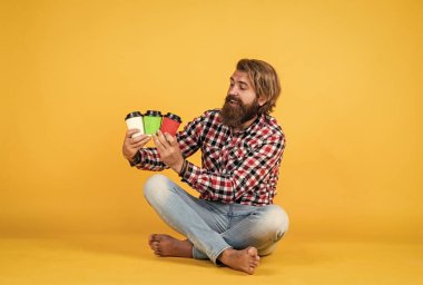 Kahveci seçimi. Evde sabah havası var. İlham konsepti. Hipster adam kahve içer. Beyaz bardak tutan yakışıklı sakallı adam. Bardakla içecek. Çay ya da kahve içmek. Günaydın..