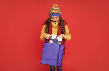 Hediyeler ve hediyeler. Satın alınmış alışveriş çocuğu. Paketi olan çocuk. Doğum günün kutlu olsun. Kara Cuma indirimi. Mevsimlik Noel satışları. Açık kutuda neşeli bir genç kız. Boks günü.