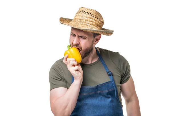 앞치마와 모자를 남자가 바탕에 채소를 깨물고 — 스톡 사진