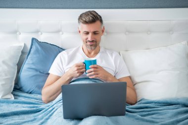 Olgun bir adamın laptopta kahve ile birlikte çalışmasına sevindim..