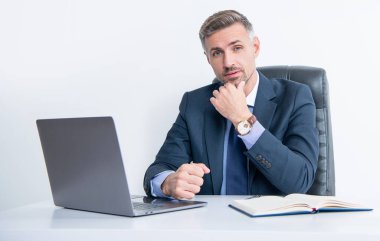 Masada dizüstü bilgisayarı olan olgun bir ofis çalışanı..