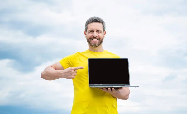 Mann Zeigt Mit Dem Finger Auf Laptop Auf Himmel Hintergrund — Stockfoto