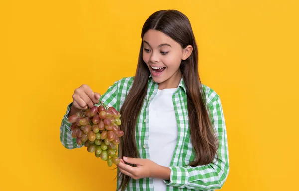 Erstauntes Kind Mit Reifem Traubenstrauß Auf Gelbem Hintergrund — Stockfoto