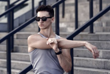 İyi esneme hareketleri. Adam esniyor. Harika bir ısınma. Kaslarını hazırlıyor. Formda ve sağlıklı kalmak. Egzersiz için ısınıyorum. Esneklik. Sınırlarınızı zorlayın. Yoga enerji verir..