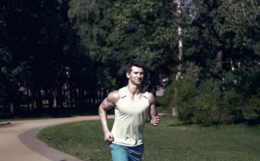 Doğal çevre üzerindeki güneşli yaz gününde Park'ta koşan adam. Başarı, hedef, gelecekteki kavramı. Spor, enerji, aktivite