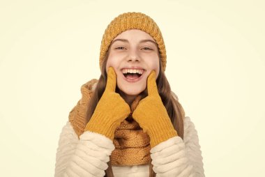 Mükemmel gülümseme. çocukluk mutluluğu. Küçük bir çocuk beyazın üstüne örgü giyer. Şapka eldivenli ve kazaklı çocuk. Sonbahar modası. Sıcak tutacak kıyafetler. Kış kıyafetleri içinde mutlu bir genç kız..