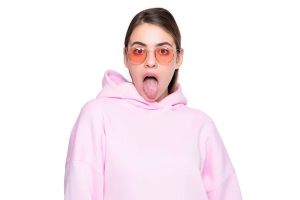 クレイジー女の子スティックアウト舌でカジュアルなピンクパーカーとガラス絶縁上の白 — ストック写真