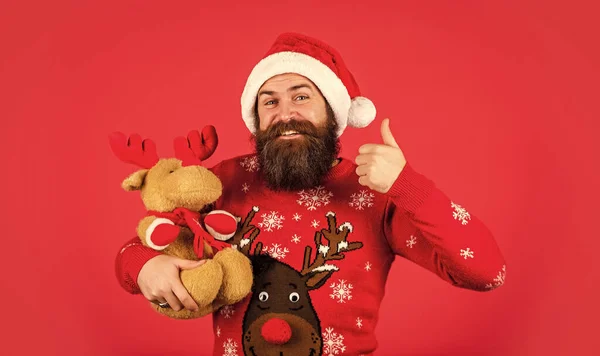 おもちゃ屋さん 新年明けましておめでとう サンタクロース クリスマスの象徴 クリスマス 子供への贈り物だ サンタさん 髭の男のトナカイのおもちゃ プラッシュシカ ヒップスター男はクリスマスプレゼントを保持します — ストック写真