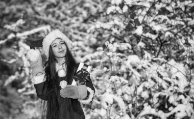 Xmas hediye kutusu olan çocuk. Kış tatilini neşeyle geçir. Noel Baba 'dan bir hediye. Küçük kız alışverişe gidiyor. Noel Baba kostümlü küçük bir kız. Karlı kış doğası. Mutlu yıllar. Boşluğu kopyala.