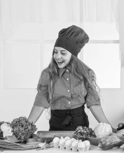 幸せな10代の女の子は野菜を調理する プロのシェフの制服を着た子供 子供は帽子とエプロンを作る キッチンの女の子 健康的なオーガニック食品です 食事とビタミン 幸せな子供時代 — ストック写真