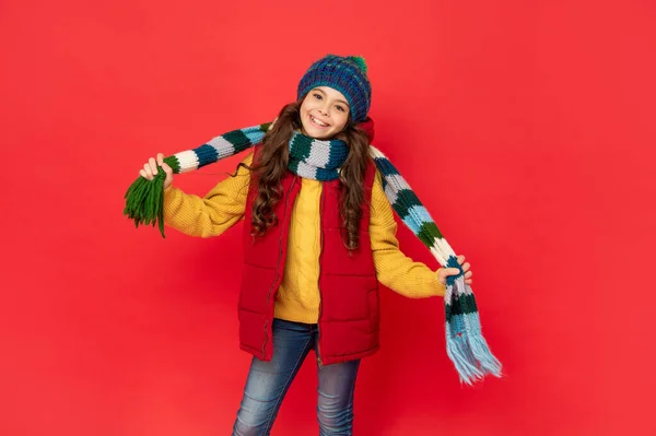 Glückliches Kind Mit Gestrickter Wintermütze Hält Schal Auf Rotem Hintergrund — Stockfoto
