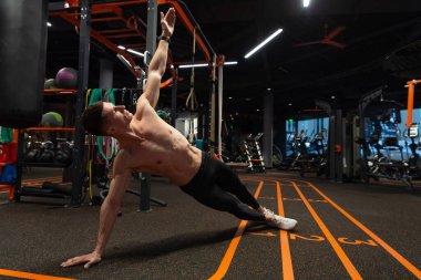 Sporcu spor salonunda yan tahta egzersizi yapar. Beden eğitiminde yan tahta egzersizi. Spor ve spor. Spor salonunda atletizm egzersizi..
