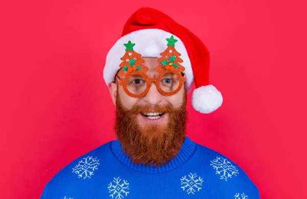 クリスマスパーティーの楽しみ パーティのメガネの陽気な男はクリスマスに楽しい時間を過ごす サンタさんは赤を背景に隔離されたクリスマスパーティーで楽しんでいます — ストック写真