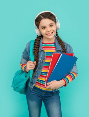 Mavi sesli kurs dinleyen mutlu genç kız. Kulaklıkla sesli kitap dinleyen bir genç. Dinleme becerileri. Okul eğitimi.