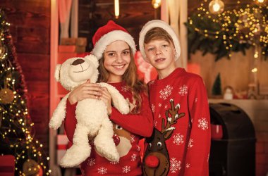 Çocuklar, Noel tatiliyle tanışın. Joy ve Noel. Aile Noel 'i kutlar. Birliktelik konsepti. Şenlikli atmosfer noel günü. Aile görünüşü. Süveter. Oğlan ve kız Noel Baba şapkaları.